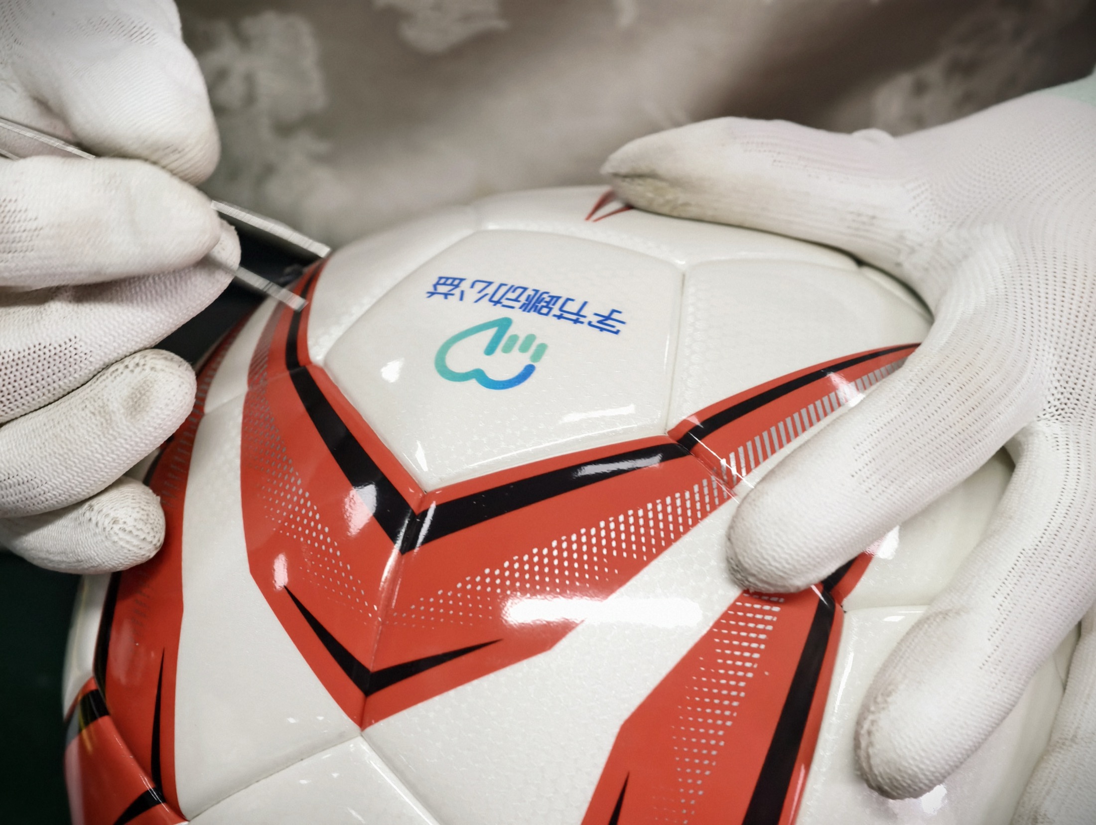 Football finishing and quality inspection at the GLORY manufacturing facility